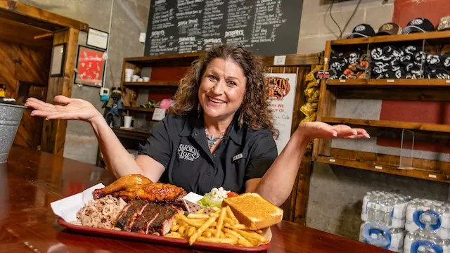 Restaurant owner at Smokin Joes with plate of food.