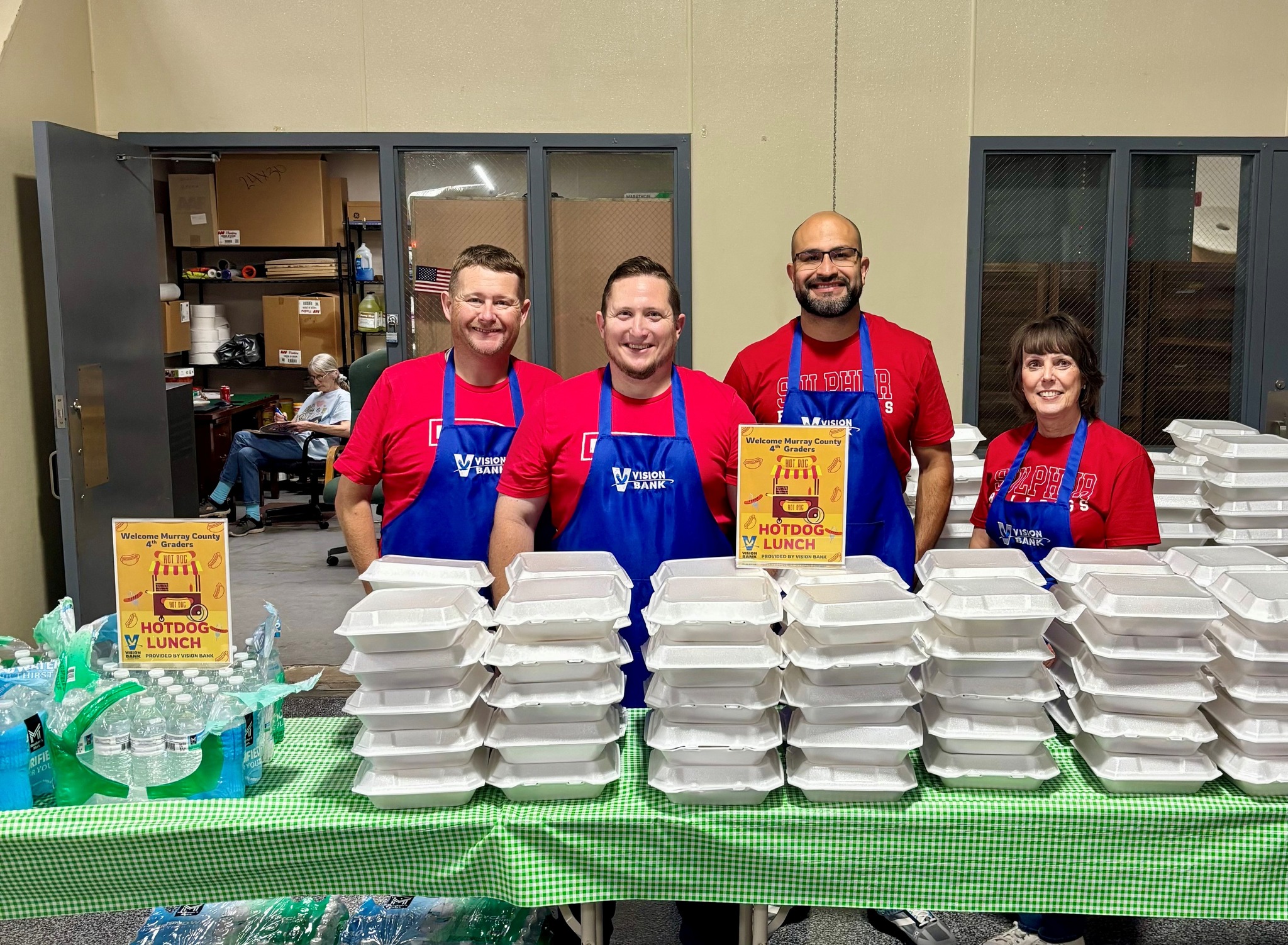 Vision Bank employees feeding students. 