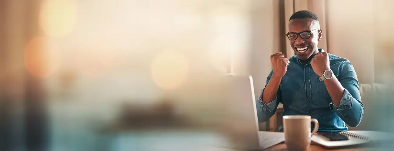 Man looking at computer cheering
