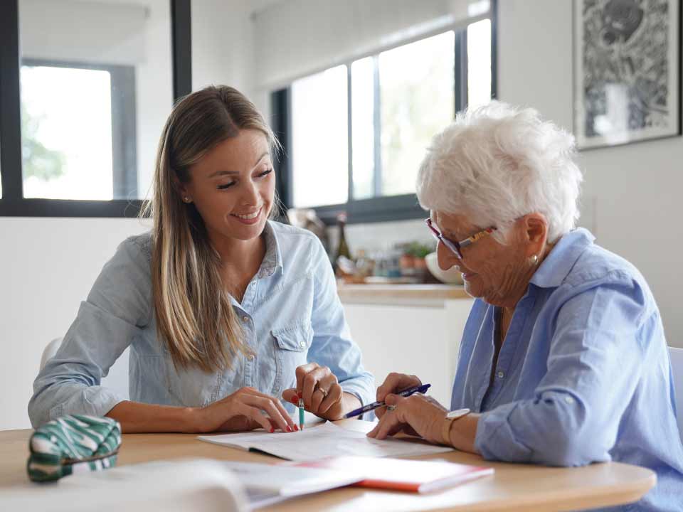 adult helping elderly parent with paperwork