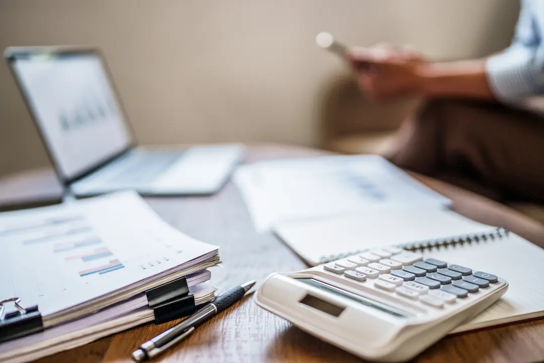 A table filled with documents and a calculator