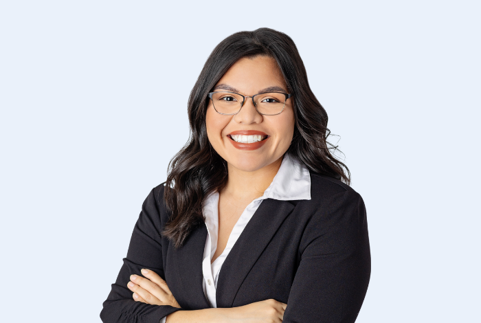 Adriana Byington, Vision Bank Norman branch manager, headshot on blue background. 